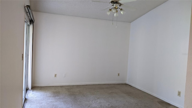 spare room featuring carpet flooring, a textured ceiling, baseboards, and ceiling fan