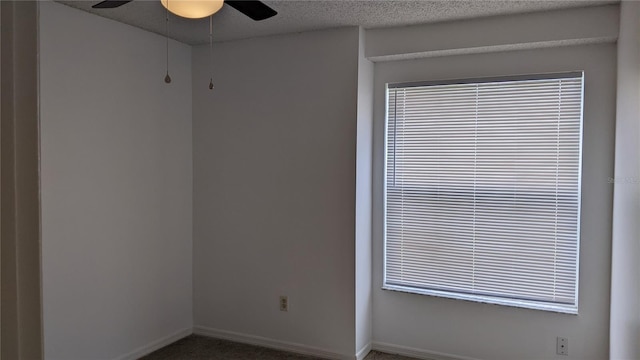 unfurnished room with baseboards, a textured ceiling, and ceiling fan