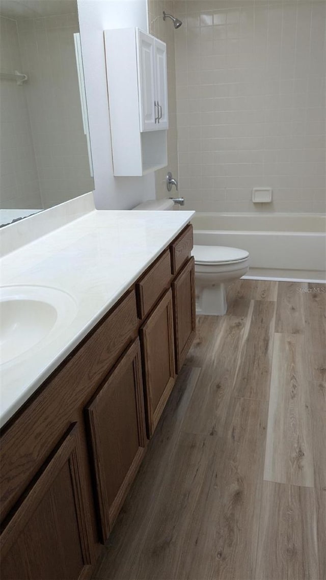 full bathroom featuring vanity, wood finished floors, bathtub / shower combination, and toilet