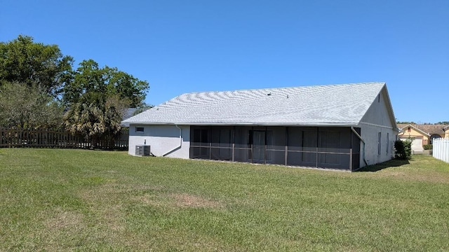 view of outdoor structure featuring central air condition unit, a sunroom, and fence