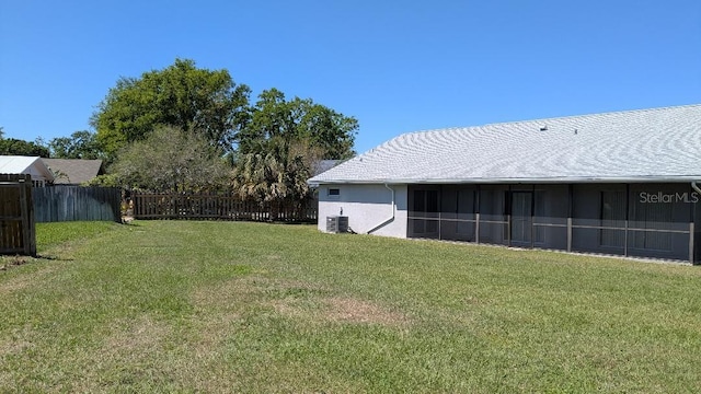 view of yard featuring central air condition unit and fence