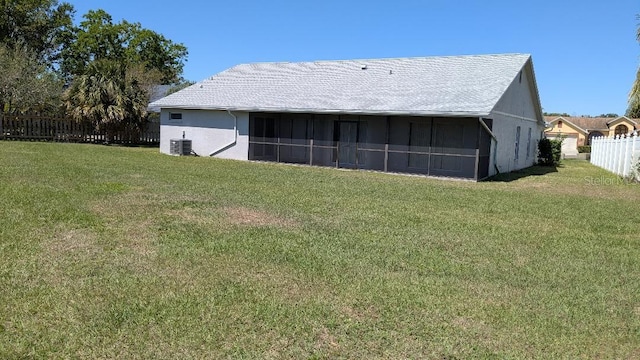 rear view of property with a yard, cooling unit, fence, and stucco siding