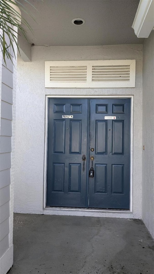 view of exterior entry featuring stucco siding