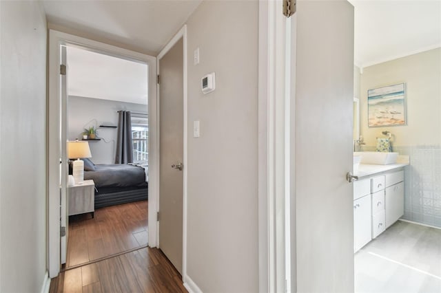 hallway with tile walls, a sink, and wood finished floors