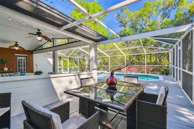 view of patio / terrace with a lanai, an outdoor pool, outdoor dining space, and ceiling fan