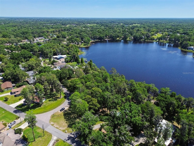 birds eye view of property featuring a forest view and a water view