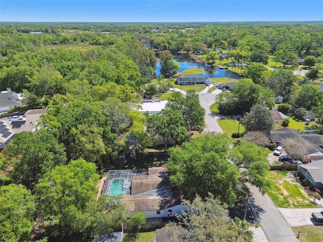 birds eye view of property with a wooded view and a water view