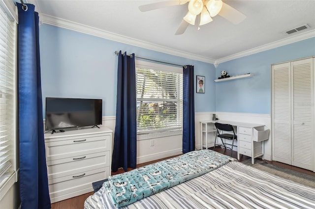 bedroom featuring visible vents, a closet, a ceiling fan, crown molding, and wood finished floors