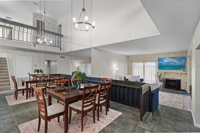 6140 Sun Blvd Unit 7, Saint Petersburg, FL 33715 - dining room with a chandelier, a high ceiling, stairs, and a stone fireplace