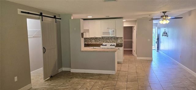 5725 80th St N Unit 107, Saint Petersburg, FL 33709 - kitchen with white microwave, range, white cabinets, a ceiling fan, and decorative backsplash