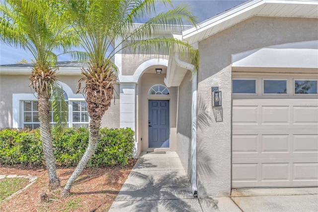 property entrance featuring stucco siding and an attached garage