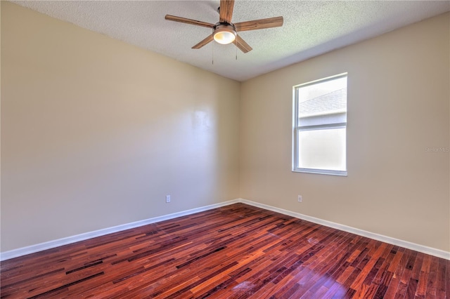 spare room with dark wood finished floors, a textured ceiling, baseboards, and ceiling fan