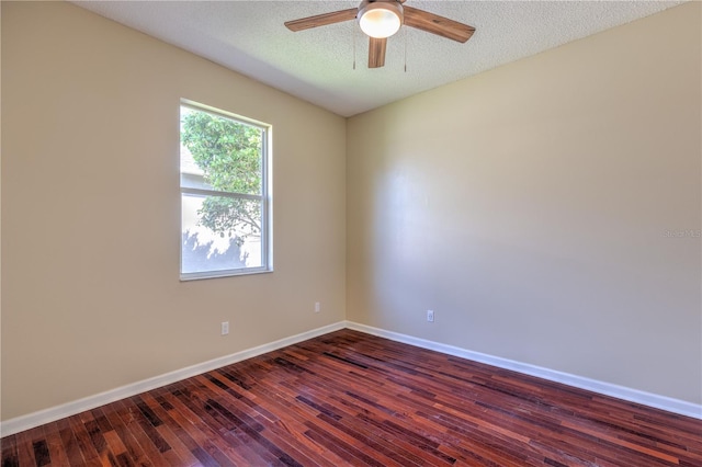 spare room featuring baseboards, a textured ceiling, dark wood-style floors, and a ceiling fan