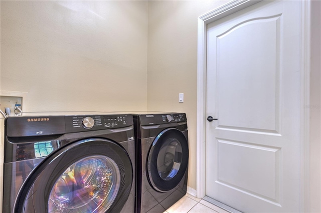 laundry room featuring washer and clothes dryer, laundry area, and light tile patterned floors