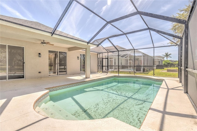 outdoor pool featuring glass enclosure, a patio, and a ceiling fan