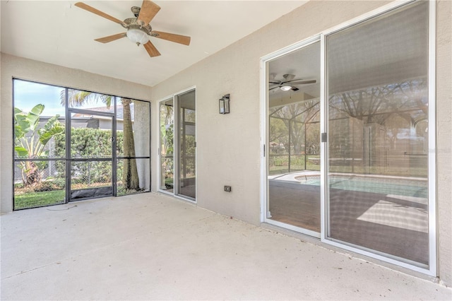 unfurnished sunroom featuring ceiling fan