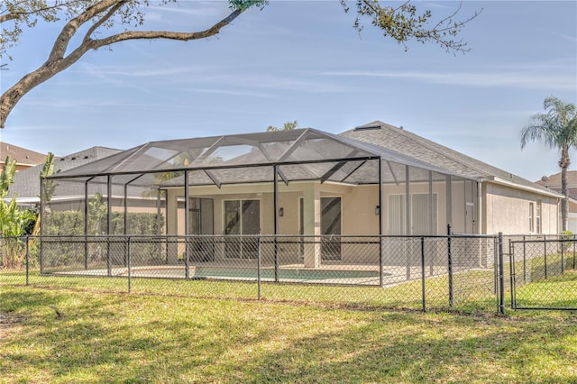 back of property with fence, a lawn, and stucco siding