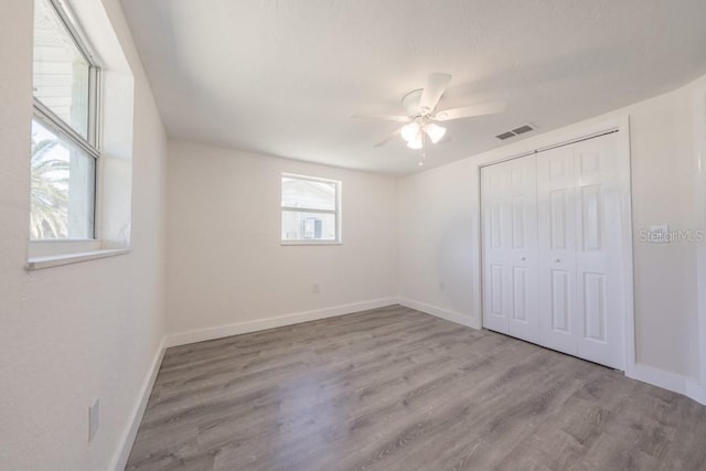 7322 Mako Dr, Hudson, FL 34667 - unfurnished bedroom with a closet, wood finished floors, baseboards, visible vents, and ceiling fan