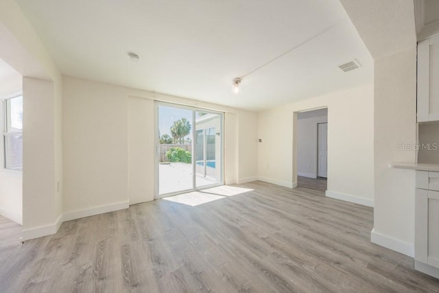 7322 Mako Dr, Hudson, FL 34667 - unfurnished living room featuring baseboards, visible vents, and light wood-type flooring