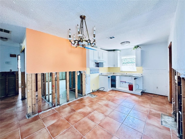 1800 New Hampshire Ave NE, Saint Petersburg, FL 33703 - kitchen with white cabinets, light tile patterned floors, visible vents, and under cabinet range hood