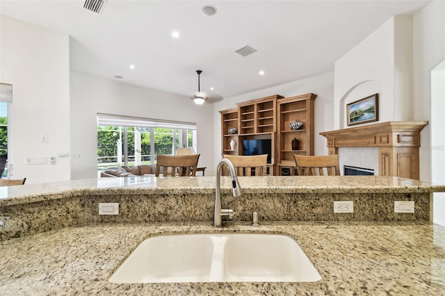 601 Viento De Avila, Tampa, FL 33613 - kitchen with light stone counters, a sink, a fireplace, open floor plan, and recessed lighting