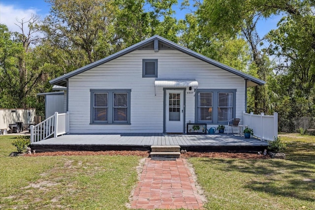 rear view of house with a yard and a wooden deck