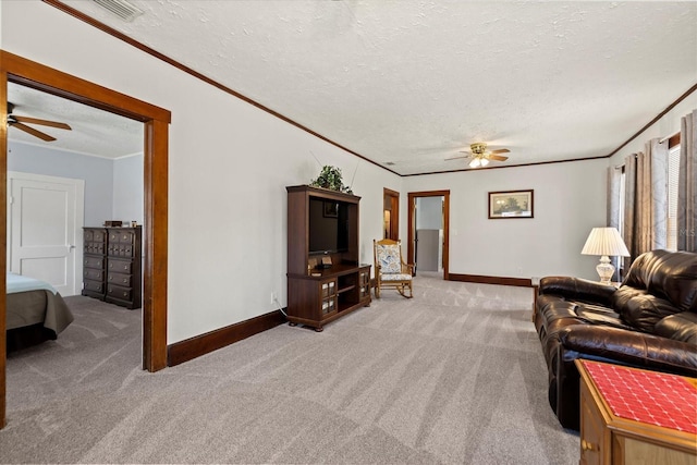 living area featuring a textured ceiling, crown molding, light colored carpet, and ceiling fan