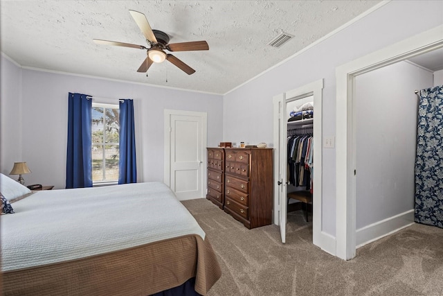 bedroom featuring crown molding, carpet flooring, visible vents, and a textured ceiling