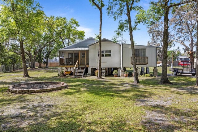 rear view of house with a yard, stairway, and a sunroom