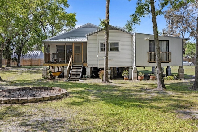 back of property featuring a lawn, stairs, and a sunroom