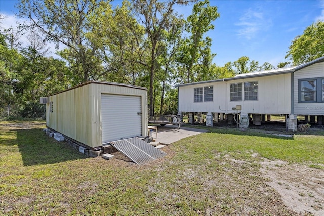 rear view of house featuring metal roof, an outbuilding, and a lawn