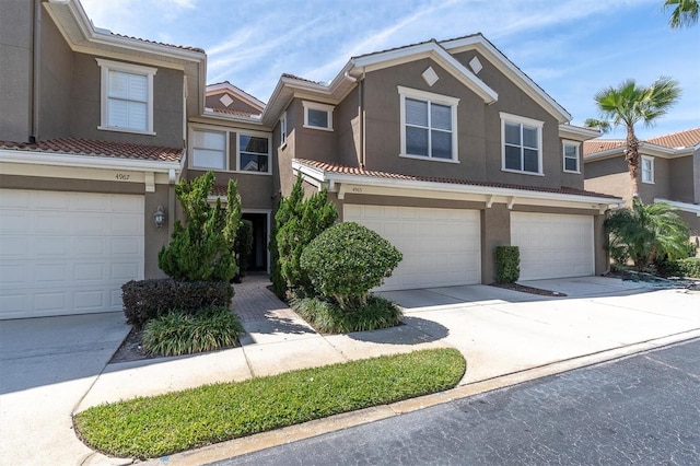 view of front facade featuring stucco siding, concrete driveway, and a tile roof