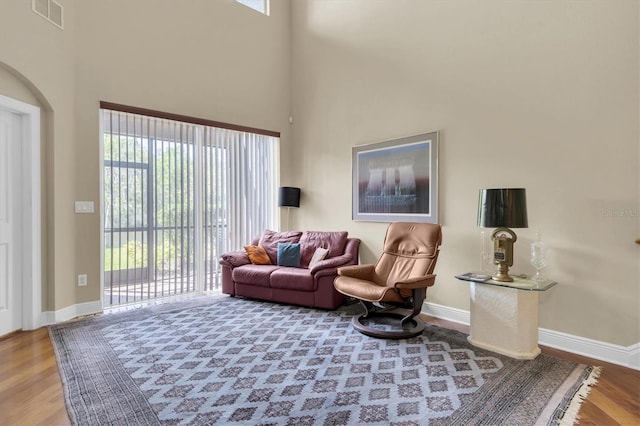 living area featuring visible vents, baseboards, and wood finished floors