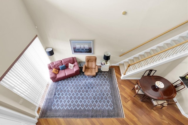 living area featuring stairs, wood finished floors, and baseboards