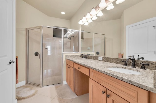 full bathroom with a shower stall, double vanity, tile patterned floors, and a sink
