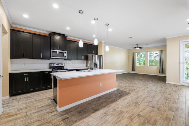 6732 Rocky Park St, Tampa, FL 33625 - kitchen with stainless steel appliances, a sink, crown molding, ceiling fan, and a center island with sink