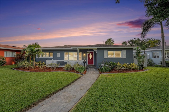 ranch-style house featuring a front lawn and stucco siding