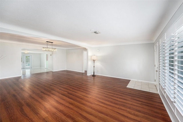 spare room featuring visible vents, baseboards, and wood finished floors
