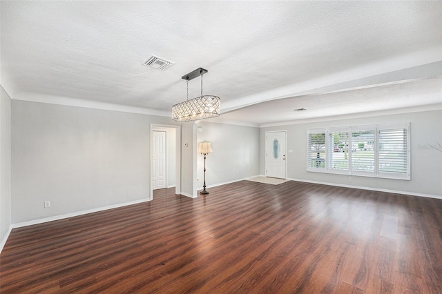 unfurnished living room featuring baseboards, visible vents, and dark wood-style floors