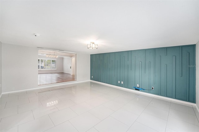 tiled spare room featuring baseboards