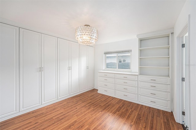 walk in closet featuring wood finished floors and a chandelier