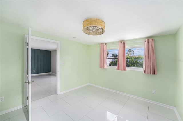 spare room featuring baseboards and light tile patterned floors