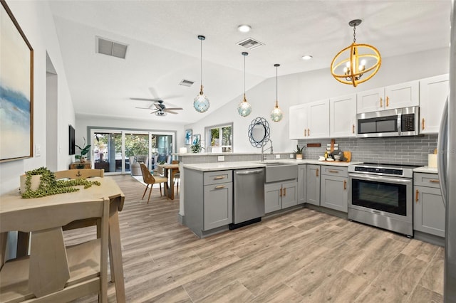 kitchen with gray cabinets, visible vents, appliances with stainless steel finishes, and a peninsula