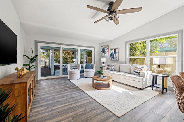 living area featuring vaulted ceiling, wood finished floors, and a ceiling fan