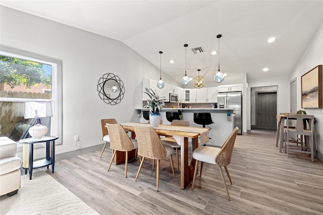 dining area with visible vents, light wood-style floors, lofted ceiling, and recessed lighting