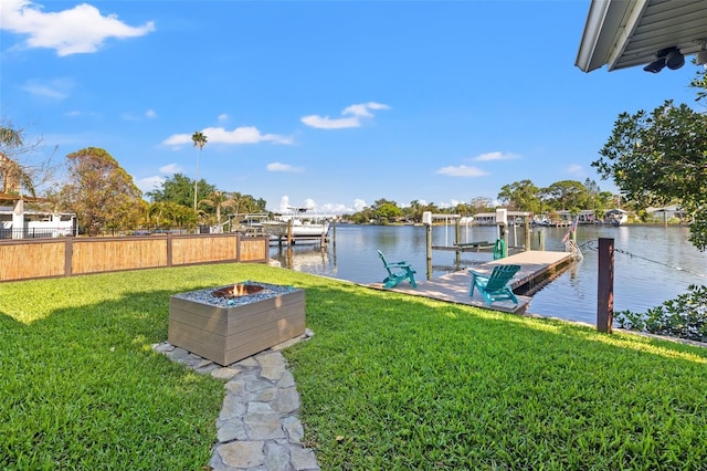 dock area with an outdoor fire pit, fence, a water view, and a yard