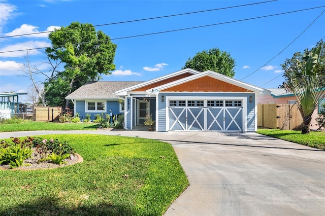 view of front of home featuring a front lawn, fence, an attached garage, and concrete driveway