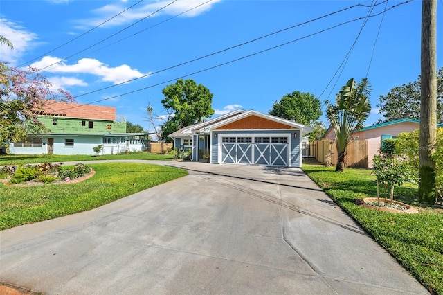 view of front of home with driveway, a front yard, and fence