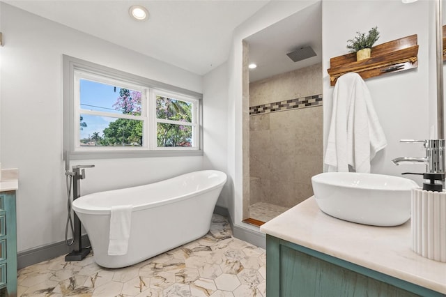 full bathroom featuring vanity, a freestanding tub, recessed lighting, marble finish floor, and tiled shower