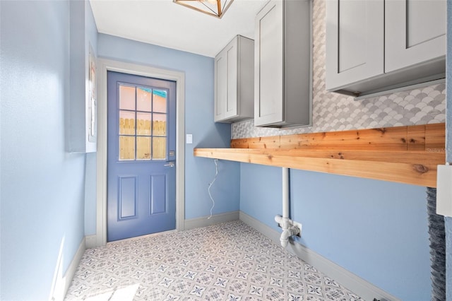 laundry area featuring baseboards